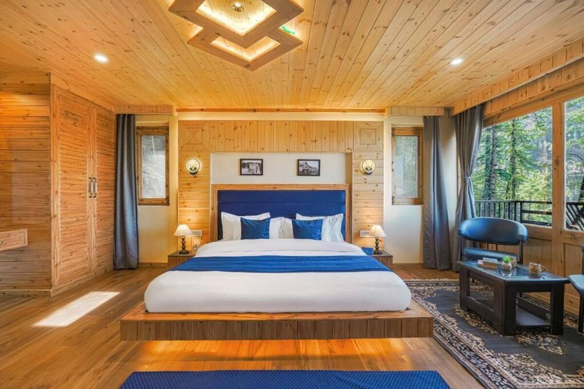 A wooden-paneled bedroom with a bed, bedside tables, and a view of the outdoors.