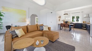 En moderne stue med sofa, sofabord og spiseplads.
