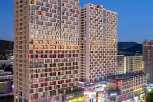 Un edificio alto con varios pisos, ventanas amplias y una entrada destacada en la base.
