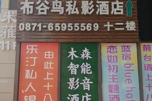 A hotel sign with contact information and a green arrow indicating direction. - Kunming Musen Hotel University Town South High-speed Railway Station (Kunming)