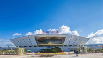 A large, modern building with a unique architectural design, featuring a central open space and a prominent entrance.