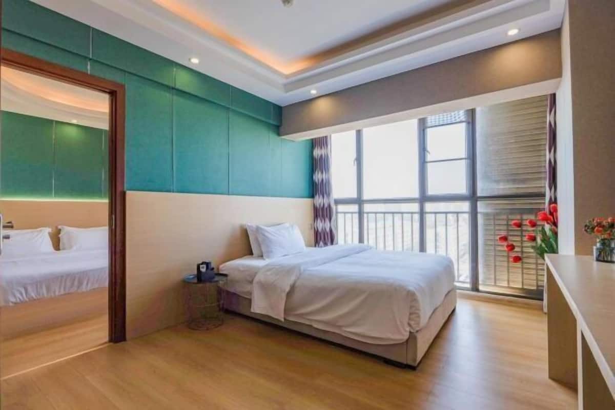 Una habitación de hotel con una cama, una mesita, un ventanal con vistas y un espejo.