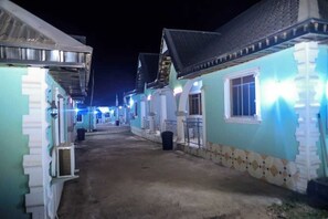 A narrow alleyway between buildings with tiled roofs and white walls.