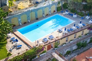 Ein Pool auf dem Dach mit Liegestühlen und einer Steinterrasse.