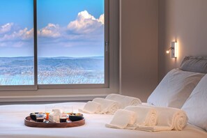 A hotel room with a large window, a bed with white linens, a tray with breakfast items, and a view of a snowy landscape. - A Ca` di Chiara e Fabio - Panoramica Lago Maggiore (Lesa)