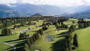 A golf course with a view of mountains and a small town in the background.