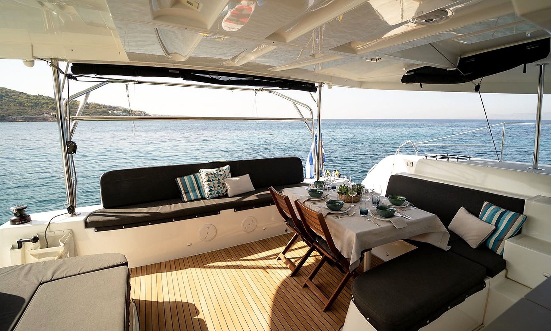 L'intérieur d'un yacht comprenant un espace repas, des sièges et une vue sur la mer.