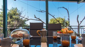 A breakfast table with a coffee pot, a bowl of fruit, and a glass of orange juice. - Apartment Sunset 3 (Trogir)