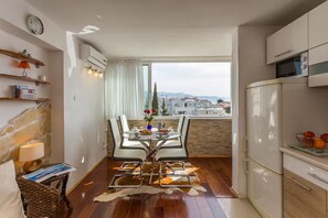 Eine moderne Küche mit Essbereich, Blick auf die Stadt und einer Steinwand.