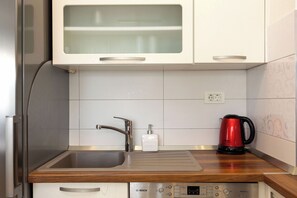 A kitchen with a stainless steel sink, a red kettle, and a Bosch dishwasher. - Apartment Znjan Park and Stay (Split)