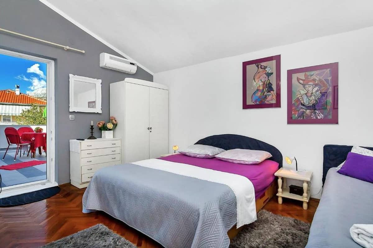 Un dormitorio con cama, cómoda, silla y una obra de arte en la pared.