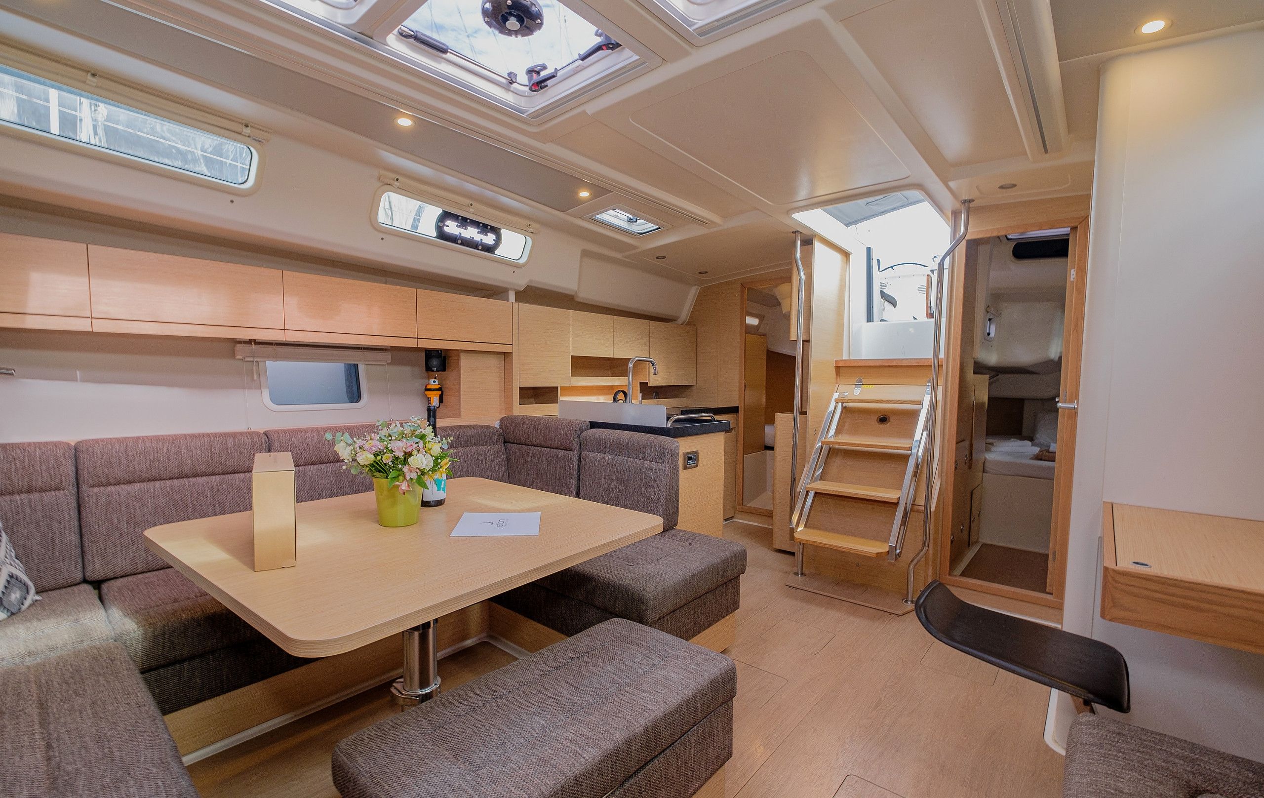 A compact interior with a dining area, seating, a kitchenette, and a small bathroom.