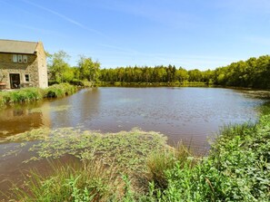 A stone building with a river in front, surrounded by greenery. - Hassop, Matlock - A Charming Retreat (Matlock)
