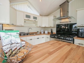 A modern kitchen with white cabinets, a stainless steel range hood, and a wooden countertop. - Daisy, Eardisland. 2 bedrooms. (Leominster)