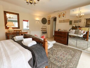 A bedroom with a bed, a dresser, a mirror, and a patterned rug.