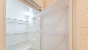 Interieur van een koelkast met meerdere planken en een vriesvak.
