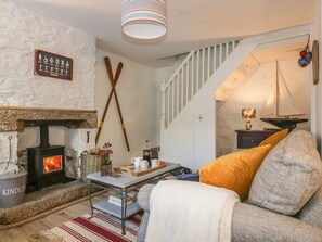 A cozy living room with a fireplace, a staircase, and a sailboat decoration. - 14 CLIFF STREET, open-plan,in Mevagissey (St. Austell)