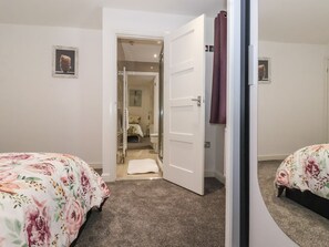 A bedroom with a bed, a door leading to a bathroom, and a small hallway. - 4 Manor Garth near Withernsea. (Withernsea)