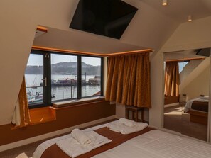 A hotel room with a large window, a bed, a TV, and a mirror. - Apartment 3, Scarborough (Scarborough)