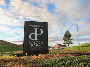 A welcome sign for Dalton Park Outlet Shopping Destination.