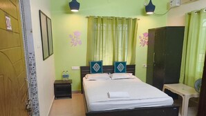 Ein Schlafzimmer mit Bett, Nachttischen, einem Kleiderschrank und einem kleinen Tisch.