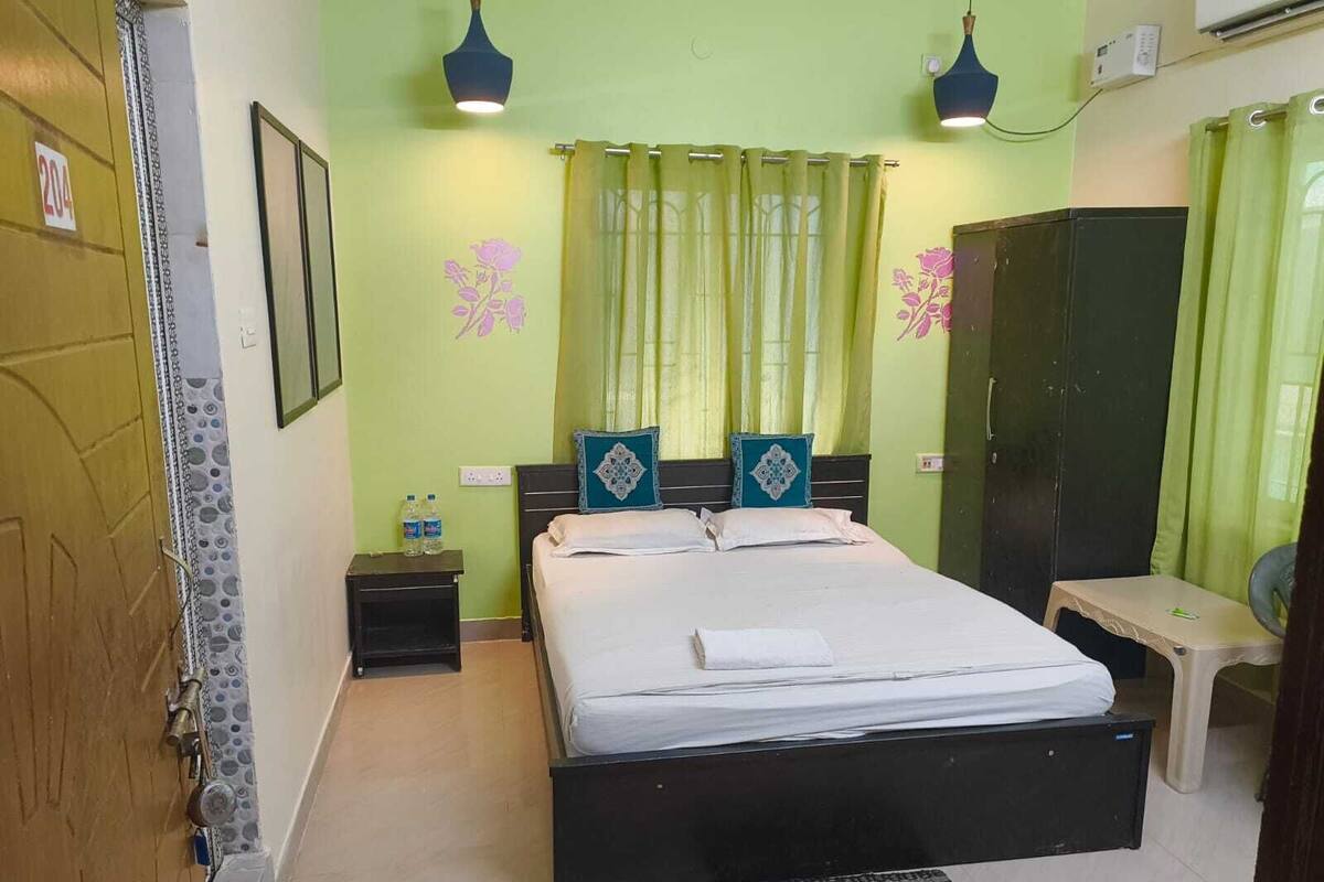 A room with a bed, bedside tables, a wardrobe, and a small desk.