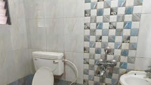 Ein Badezimmer mit Toilette, Waschbecken und Fliesen.
