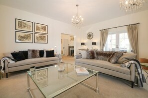A living room with two sofas, a glass coffee table, and a chandelier. - The Coach House, Bolney Sussex (Haywards Heath)