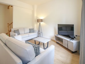 Ein modernes Wohnzimmer mit Sofa, Couchtisch und TV-Möbel.