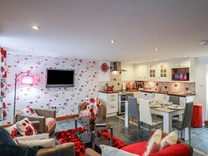 Ein modernes Apartment mit Wohnzimmer, Essbereich und Küche.