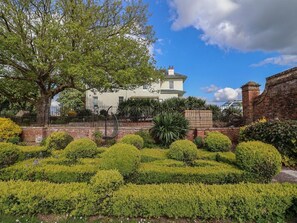 A white house with a brick wall and a garden with trimmed bushes and a tree. - Buckland House and Annex, Taunton (Taunton)
