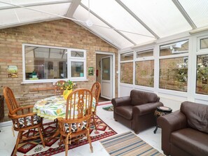 A conservatory with a dining table, chairs, and a sofa. - 5 Overstone Drive, Wisbech (Wisbech)