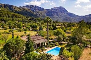 A villa with a swimming pool, surrounded by lush greenery and mountains. - Vacation Home “La Plana” with Mountain View, Pool, Garden & Terrace (Illes Balears)