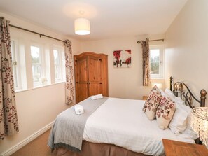 A bedroom with a bed, curtains, a wooden wardrobe, a painting, and a chandelier. - Chatsworth, Two Dales (Matlock)