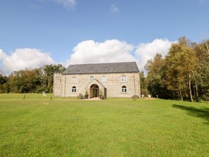 A stone building with a central entrance, surrounded by a grassy field and trees. - Chatsworth, Two Dales (Matlock)