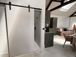 Ein modernes Interieur mit einer Schiebetür, einer Couch, einem Esstisch und einer Küchenzeile.