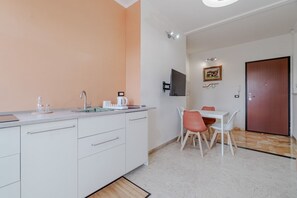 A modern kitchen with a white countertop, a sink, and a dining area with a table and chairs. - GuestHost - A bright and welcoming 57 square meters apartment, perfect for three people, located on the fourth floor of a building with an elevator (NOT accessible to disabled guests).The property enjoys an excellent location: the Bengasi metro station i (Turin)