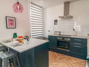 A modern kitchen with a central island, a built-in oven, and a stainless steel range hood. - Apartment 2, Scarborough, 2bed (Scarborough)