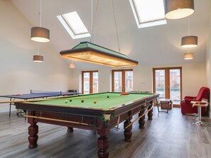 A pool table in a room with skylights, a red chair, and a small table. - Lime Cottage, Aylesbeare (Exeter)