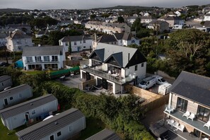 Ein Wohngebiet mit modernen Häusern, darunter ein zweistöckiges Haus mit Balkon und ein Haus mit flachem Dach.