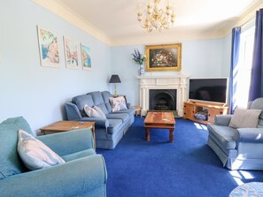 A living room with a fireplace, a television, and a sofa. - Ty Caredig, Pontardawe (Swansea)