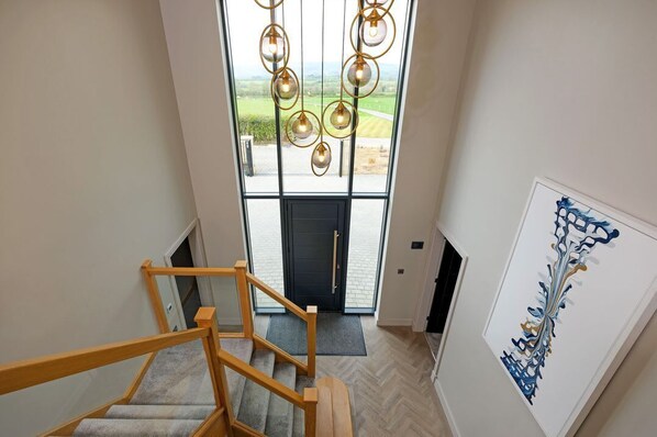 A staircase leading to a door with a view of a green landscape. - Archstone House, Langho, Lancashire (Blackburn)