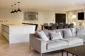 A modern living room with a sofa, a coffee table, and a dining area with chairs. - Archstone House, Langho, Lancashire (Blackburn)