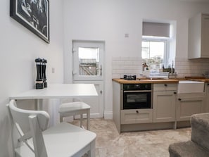 A kitchen with white cabinets, a stove, and a window.