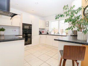 A modern kitchen with white cabinets, a black countertop, and a built-in oven. - Manor Park View, Norwich (Norwich)