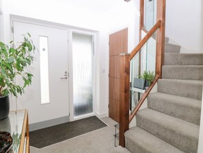 A staircase with a wooden handrail and carpeted steps leading to a door with frosted glass panels. - Manor Park View, Norwich (Norwich)