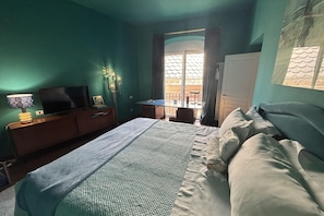 A bedroom with a bed, a desk, a chair, and a television. - Luxury Penthouse With Amazing Views (Roma)