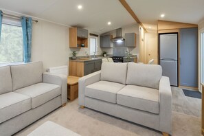 A compact living space with a kitchenette, two sofas, and a door leading to a bathroom. - Enjoy a Relaxing Stay at Marton Mere 17890 (Blackpool)