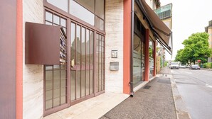 A building with large windows, a metal gate, and a sidewalk. - Roberto Flat - 10 min da Fiera di Verona (Verona)