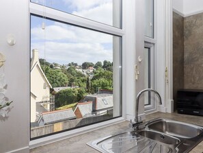 A kitchen with a large window, a stainless steel sink, and a modern design. - Kinbrae Apartment, Torquay (Torquay)